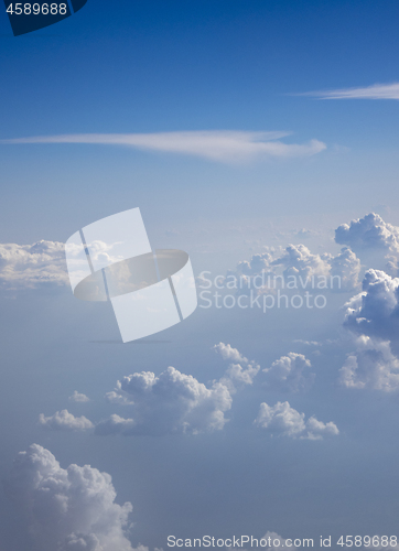 Image of Sun light through clear blue sky with fluffy clouds.