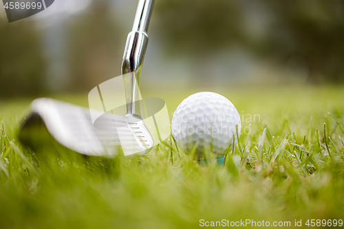 Image of Golf ball on tee in front of driver