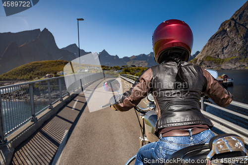 Image of Biker girl rides on road in Norway.