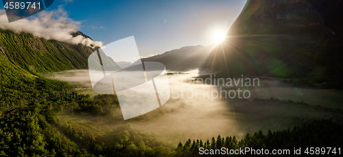 Image of Morning mist over the valley among the mountains in the sunlight