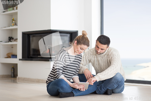 Image of Young Couple using digital tablet on cold winter day