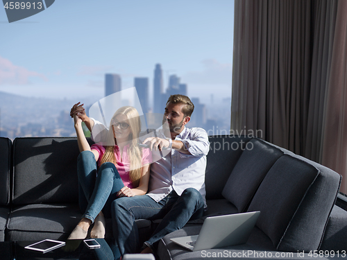 Image of Young couple on the sofa watching television