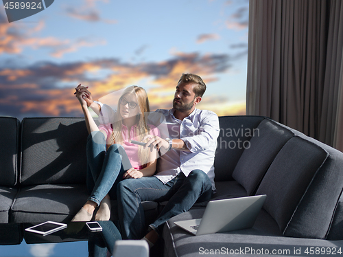 Image of Young couple on the sofa watching television