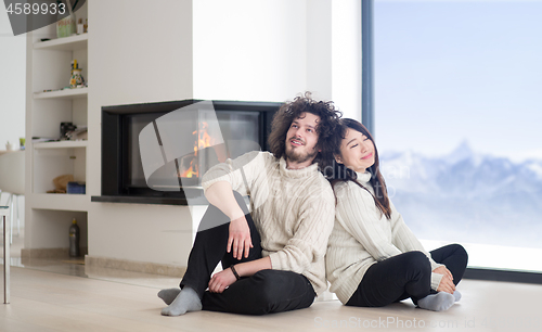 Image of happy multiethnic couple  in front of fireplace