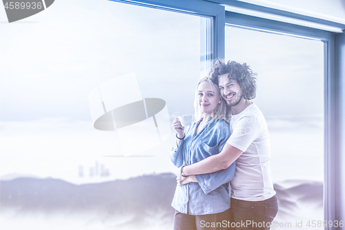 Image of young couple enjoying morning coffee by the window