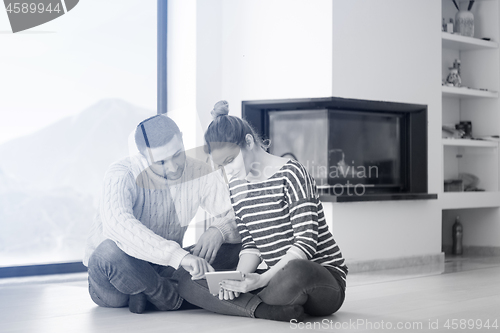 Image of Young Couple using digital tablet on cold winter day