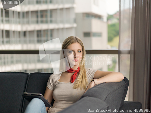 Image of young woman on sofa at home surfing web