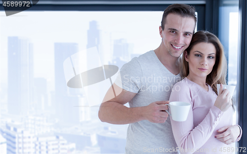 Image of young couple enjoying morning coffee by the window