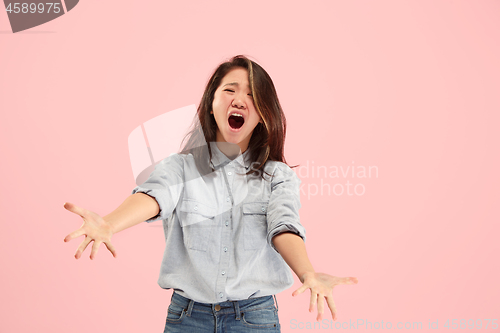 Image of The young emotional angry woman screaming on studio background