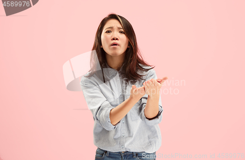 Image of Beautiful female half-length portrait isolated on pink studio backgroud. The young emotional surprised woman