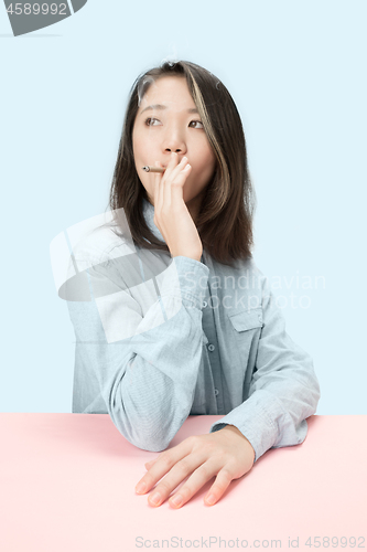 Image of Handsome young women smoking cigar while sitting at table with newspaper in sunglasses