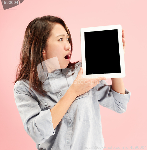 Image of Portrait of a confident casual girl showing blank screen of laptop isolated over pink background