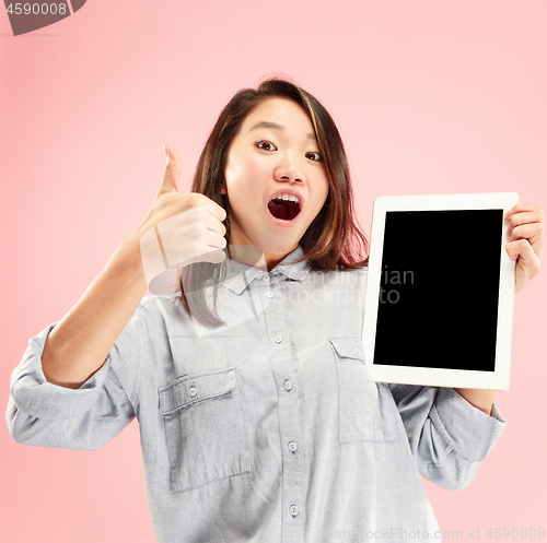 Image of Portrait of a confident casual girl showing blank screen of laptop isolated over pink background