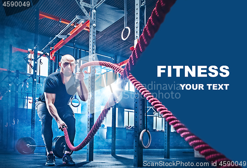 Image of Men with battle rope battle ropes exercise in the fitness gym.