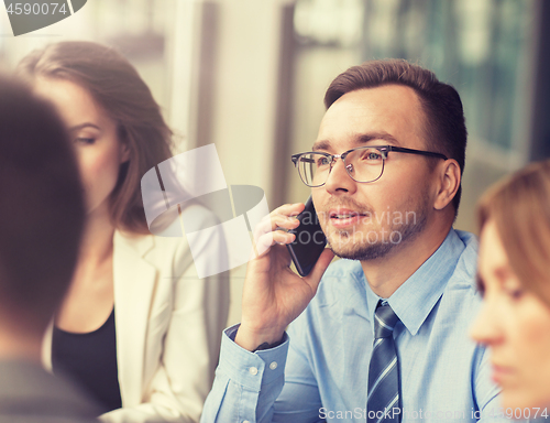 Image of businessman calling on smartphone at office