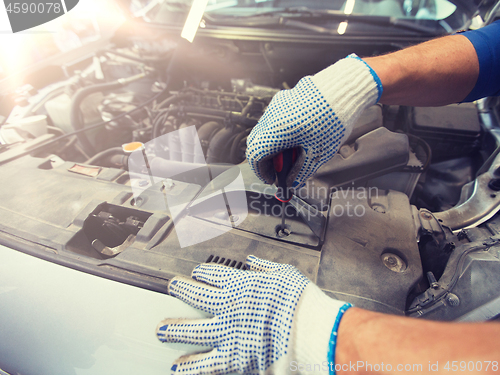 Image of mechanic man with wrench repairing car at workshop