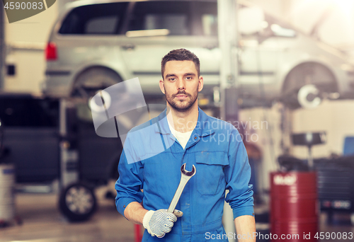 Image of auto mechanic or smith with wrench at car workshop