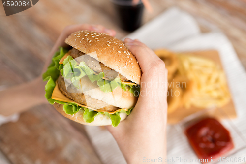 Image of close up of woman holding hamburger