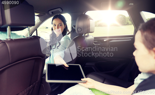 Image of happy family with tablet pc driving in car