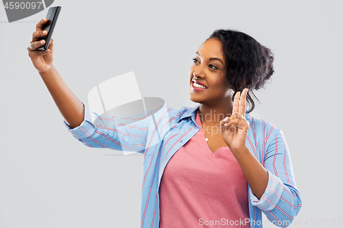 Image of african american woman taking selfie by smartphone