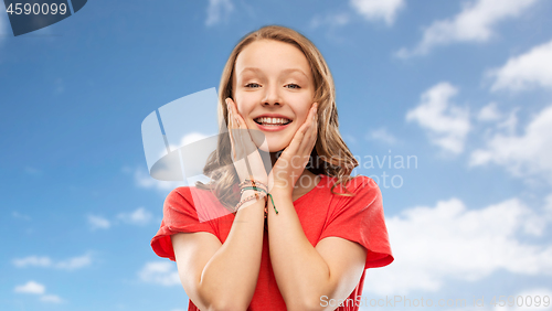 Image of smiling teenage girl in red t-shirt over sky