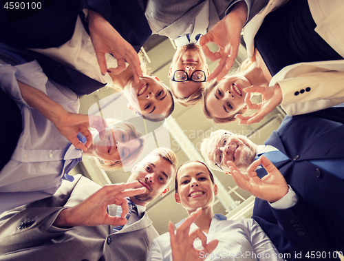Image of business people showing ok hand sign at office