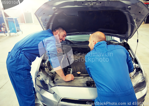 Image of mechanic men with wrench repairing car at workshop