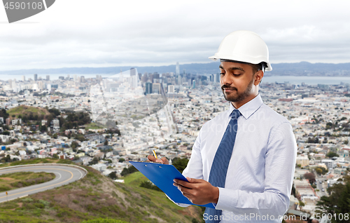 Image of architect or businessman in helmet with clipboard