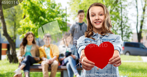 Image of smiling teenage girl with red heart outdoors