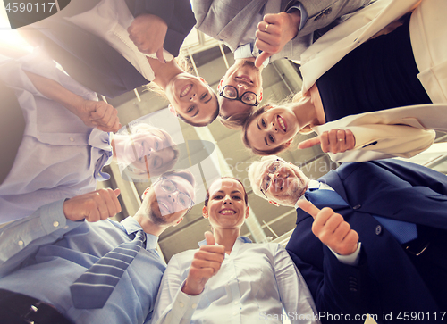 Image of business people snowing thumbs up at office