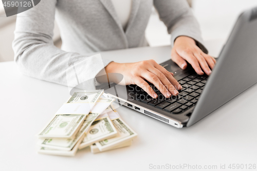 Image of close up of businesswoman with laptop and money