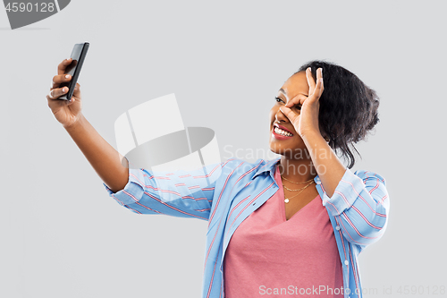 Image of african american woman taking selfie by smartphone