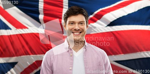 Image of smiling young man over british flag background