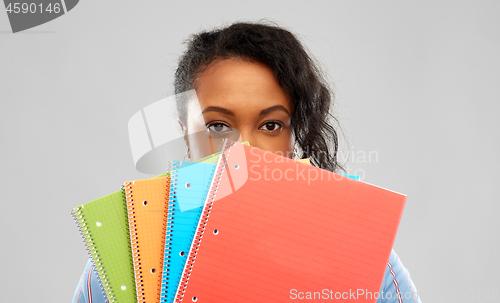 Image of shy african american student woman with notebooks