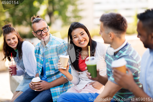 Image of friends drinking coffee and juice talking in city