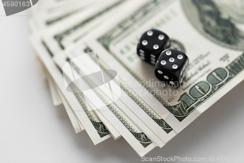 Image of close up of black dice on dollar money