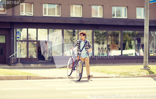 Image of young man with fixed gear bicycle on crosswalk