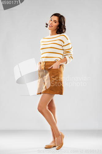 Image of young woman in striped pullover, skirt and shoes