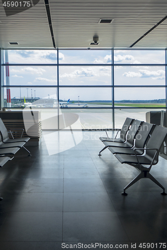 Image of Empty chairs in airport terminal with view to airplanes.