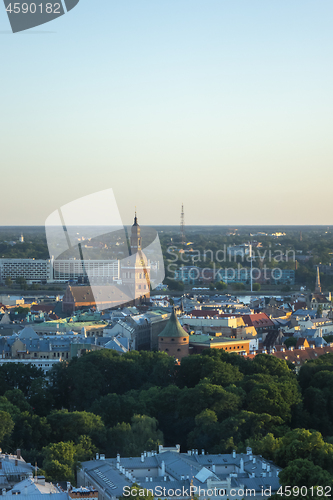 Image of Riga Cathedral among old houses of town and green trees.