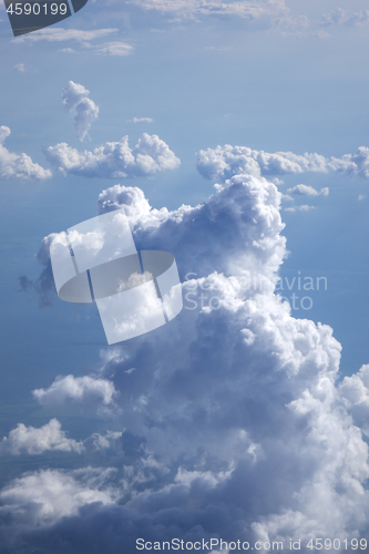 Image of Vertical background of big clouds in a blue clear sky.