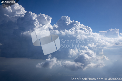 Image of Sun beams are lighting huge white cumulus clouds.