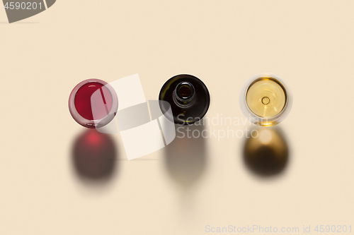 Image of Drink set from bottle and two wine glasses with shadows.