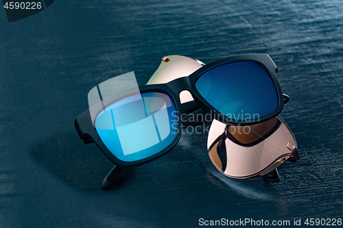 Image of Two fashionable sunglasses on a blue background.