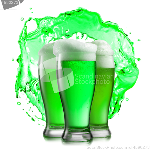 Image of Glasses of green beer on a background of green splash.