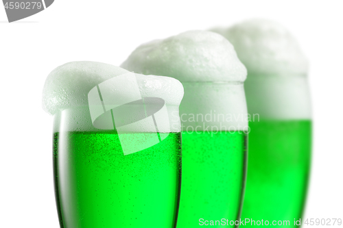 Image of Fresh green beer with thick foam in the glasses.