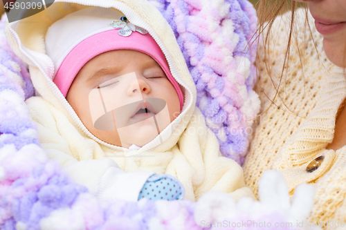 Image of Portrait of a close-up of a two-month-old girl in her mother\'s arms