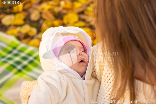 Image of Two-month-old baby sleeps in mom\'s arms