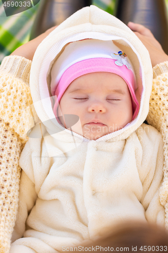 Image of On the mother\'s lap lies and sleeps two-month-old baby