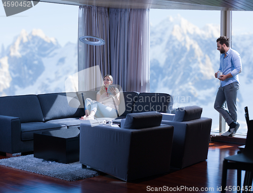 Image of couple relaxing at  home with tablet computers